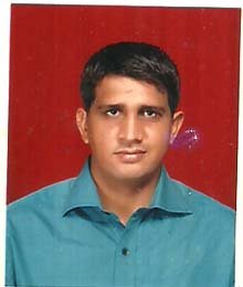 Portrait of Dr. Kapoor wearing traditional attire with academic books in background